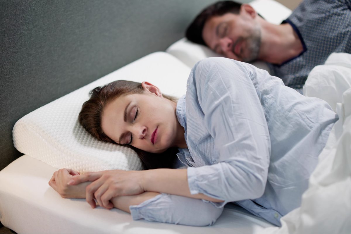 couple dormant sur un lit avec des oreillers à mémoire de forme
